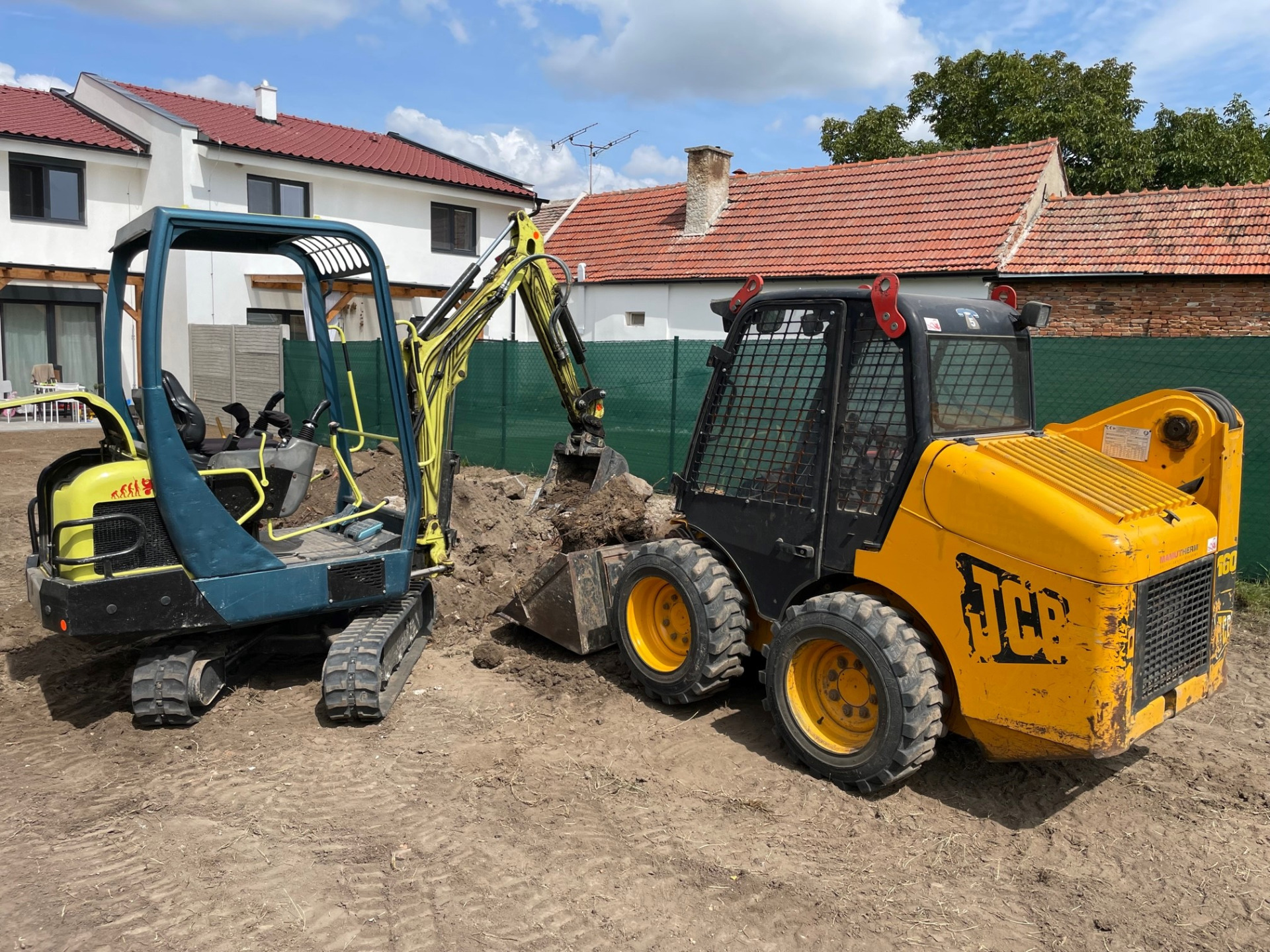 Minibagr Yanmar a smykový nakladač JCB na stavbě u rodinného domu